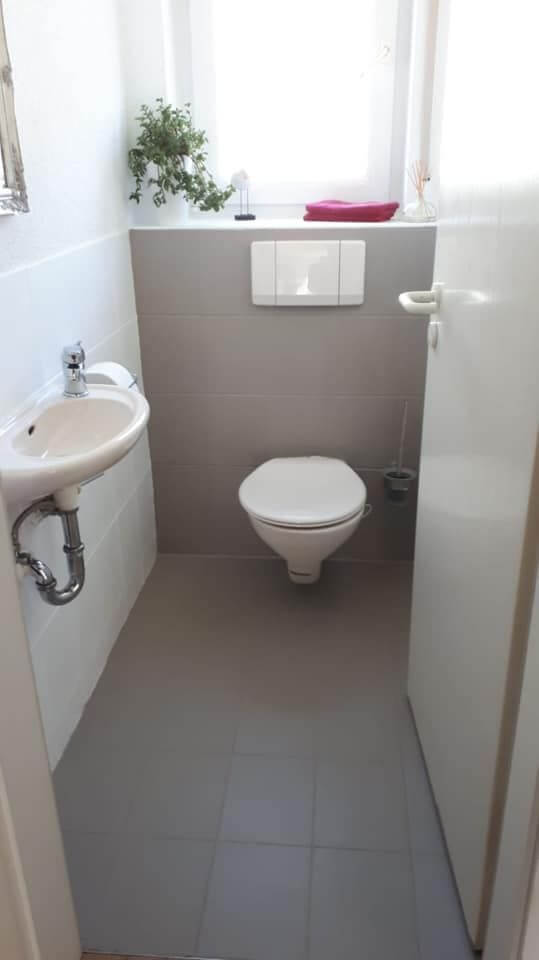 Exemplo de banheiro social com azulejos cobertos de tinta